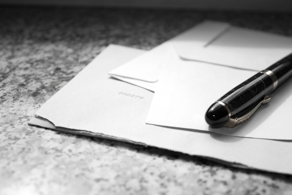 Lettera di convocazione per la mediazione ereditaria e divisione della casa di famiglia con documenti e penna su una scrivania.